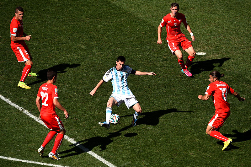 Lionel Messi rodeado por jogadores su��os em 2014, numa imagem inspirada na famosa fotografia de Steve Powell de Maradona. Nikon D4S + AF-S NIKKOR 600mm f/4, 1/3200 seg, f/5.6, ISO 400 �Matthias Hangst/Getty Images