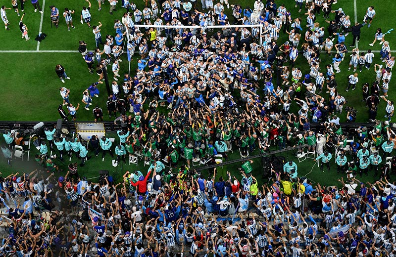 Do alto, acima do campo, Matthias Hangst capta Lionel Messi a transportar o trof�u no meio de uma multid�o de jogadores, familiares e fot�grafos ap�s a vit�ria da Argentina no Mundial de 2022. Nikon Z9 + NIKKOR Z 70-200mm f/2.8 VR S, 85mm, 1/1250 seg, f/3